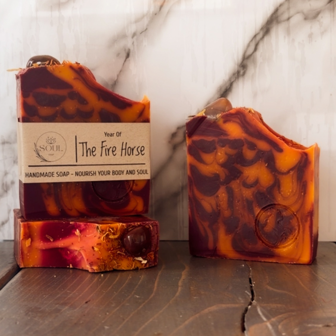 Handmade soap with marbled design and packaging labeled 'The Fire Horse' on a marble surface.