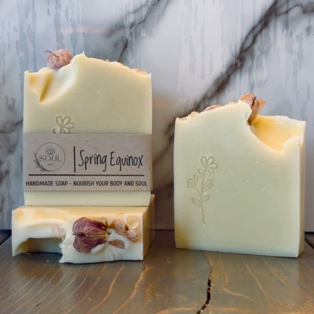 Two bars of handmade soap with 'Spring Equinox' branding on a marble surface.